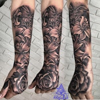 a black and grey tattoo of roses on a sleeve