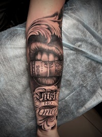 a man's forearm with a tattoo of money on it